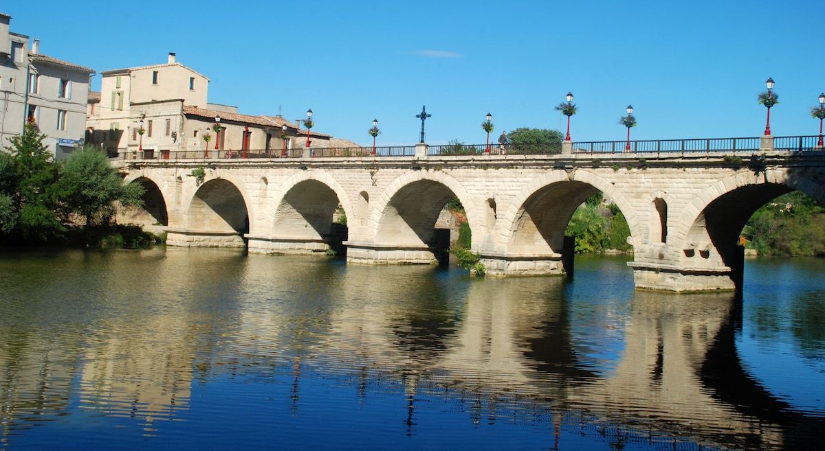 The Roman bridge at Sommières, its arches reflected in the river
