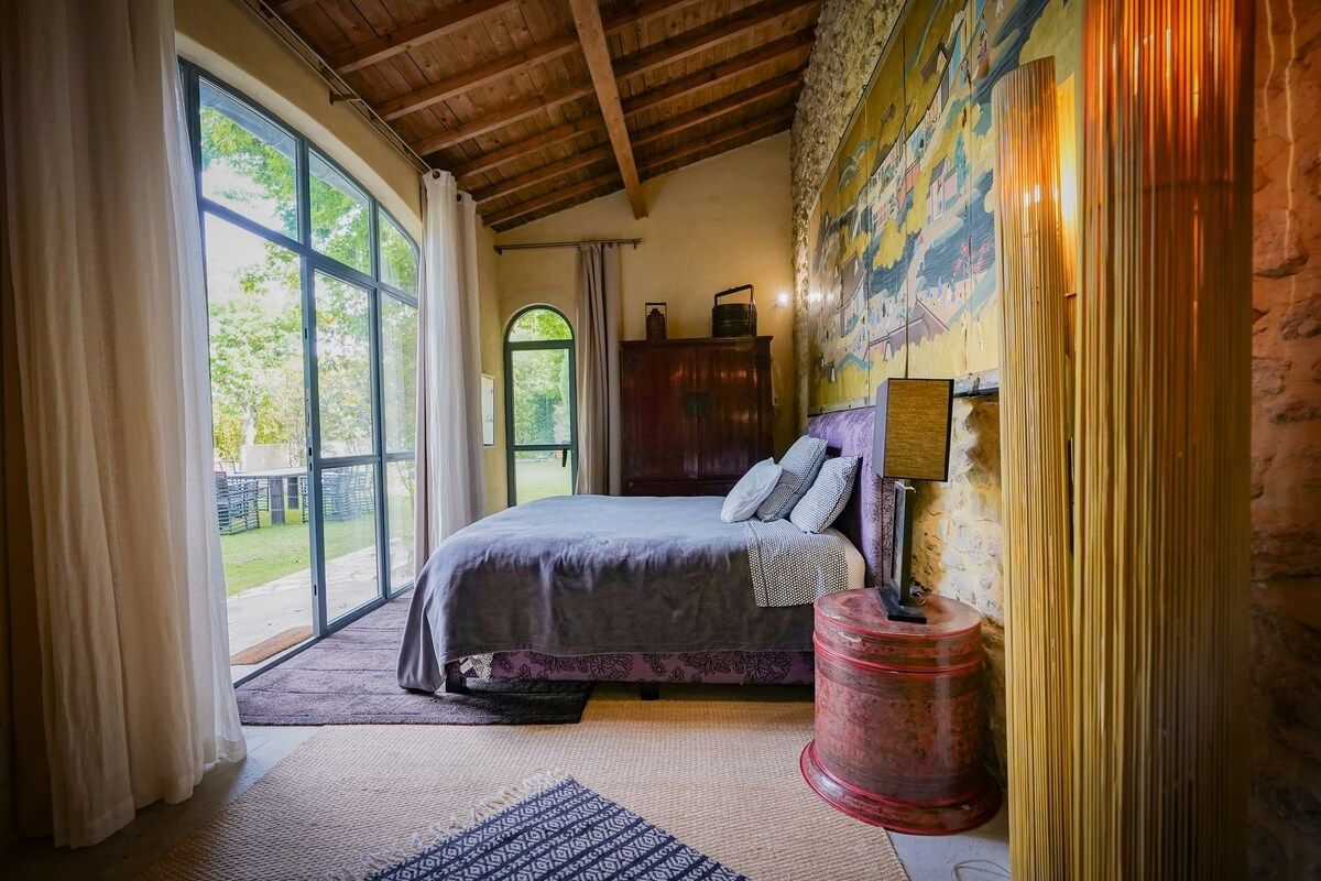 The Garden Room, its bed facing a wall of glass opening to the garden