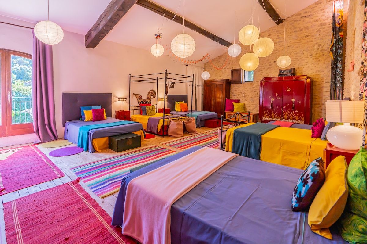 Le Dortoir, a long room lined with double beds under a beamed roof