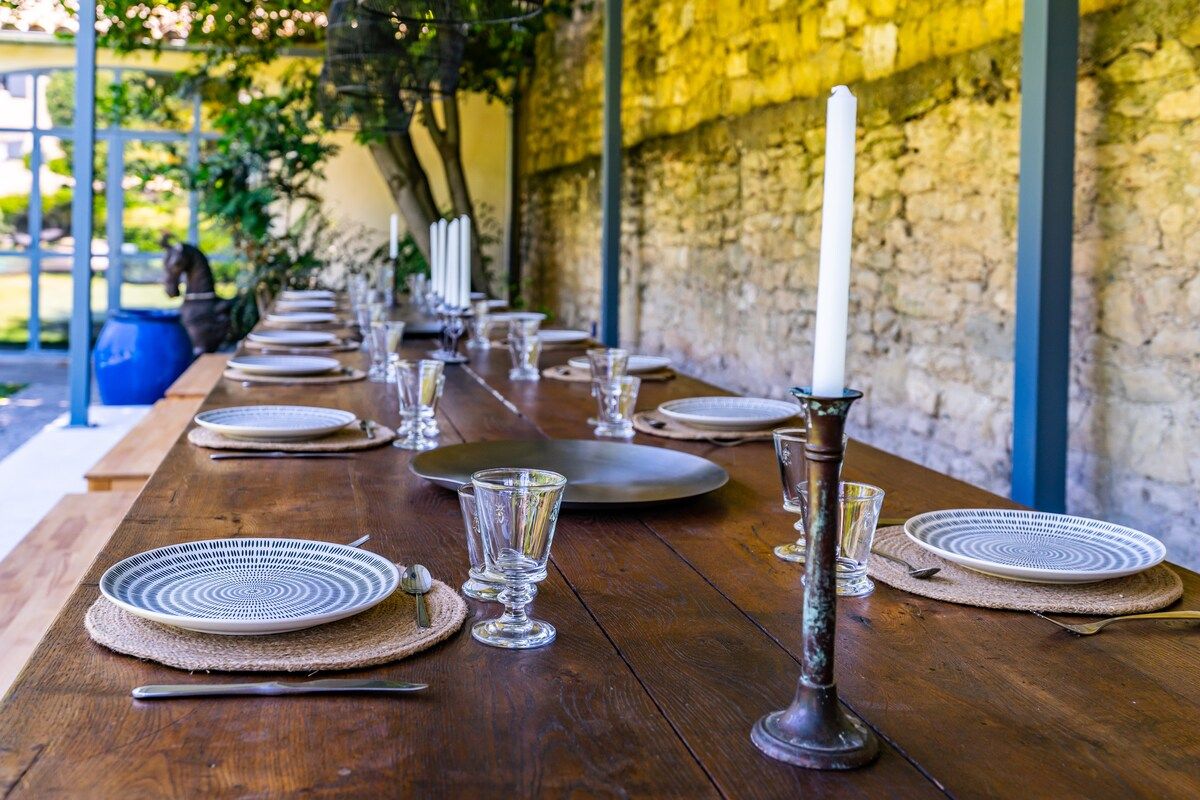 The outdoor dining terrace, its long tables laid with candles against a stone wall
