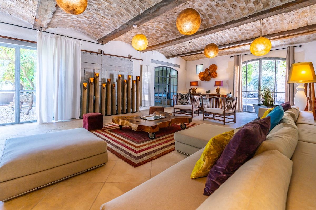 The main salon at Mas Bleu, with beamed ceiling and pendant lights